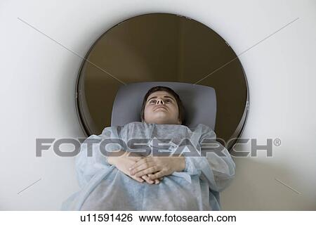 Stock Photograph - Woman lying in CAT scan machine. Fotosearch