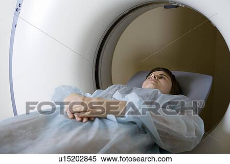 Stock Photography - Woman lying in CAT scan machine. Fotosearch