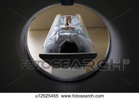 Stock Photography - Woman lying in front of CAT scan machine. Fotosearch