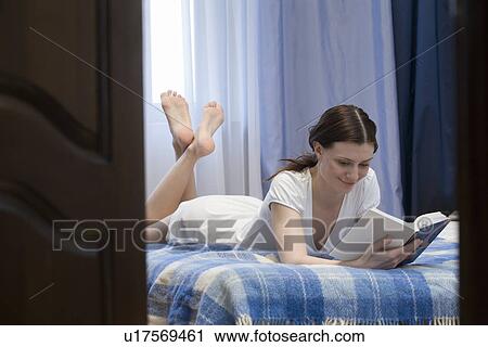 Woman lying on bed and reading book View Large Photo Image Stock Image - Woman lying on bed and reading book. Fotosearch