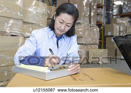 Woman making notes in distribution warehouse View Large Photo Image Stock Photo - Woman making notes in distribution warehouse. Fotosearch
