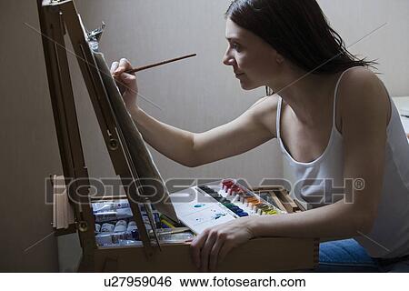 Woman painting on easel View Large Photo Image Stock Photograph - Woman painting on easel. Fotosearch