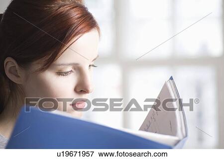Stock Photo - Woman reads blue file. Fotosearch