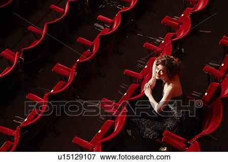 Stock Photo - Woman sitting in theatre stalls high angle view. Fotosearch