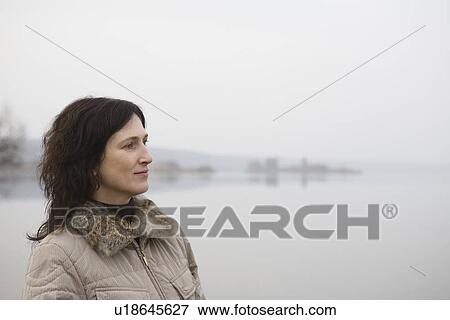 Woman standing near lake View Large Photo Image Stock Photo - Woman standing near lake. Fotosearch