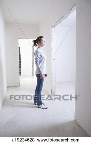 Stock Photo - Woman stands in hallway of new apartment. Fotosearch