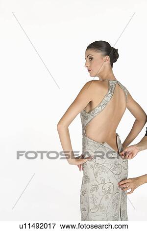 Woman stands waiting for zip to be done up on backless dress View Large Photo Image Stock Photo - Woman stands waiting for zip to be done up on backless dress. Fotosearch