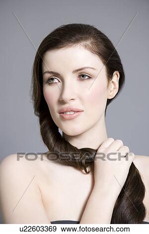 Stock Photo - Woman twisting long brown hair. Fotosearch