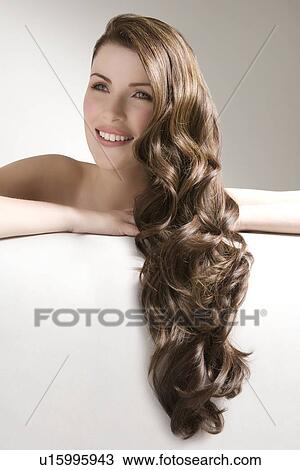 Woman with long brown curly hair View Large Photo Image Stock Image - Woman with long brown curly hair. Fotosearch