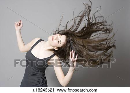 Stock Image - Woman with long brown hair dancing. Fotosearch