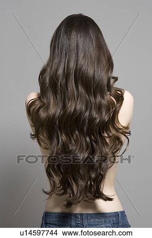 Picture - Woman with long brown wavy hair rear view. Fotosearch