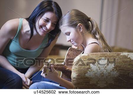 Women encourages young girl with the guitar View Large Photo Image Stock Image - Women encourages young girl with the guitar. Fotosearch