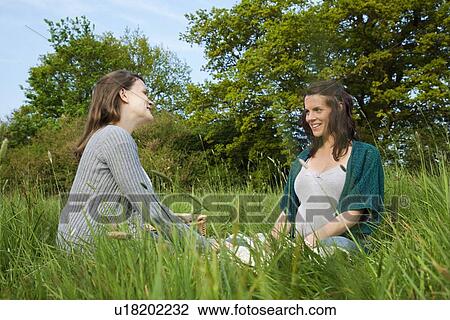Women sitting on grass View Large Photo Image Stock Image - Women sitting on grass. Fotosearch