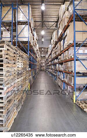Stock Photography - Wooden pallets and cardboard boxes in distribution warehouse. Fotosearch