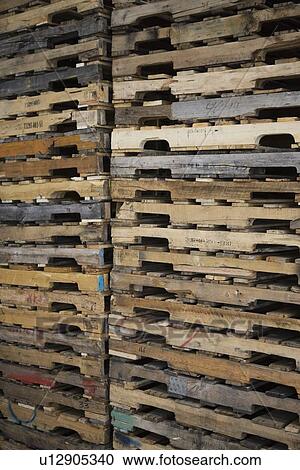 Stock Image - Wooden pallets stacked in distribution warehouse. Fotosearch