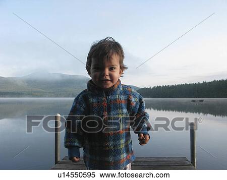 Young boy standing at end of a pier View Large Photo Image Stock Photography - Young boy standing at end of a pier. Fotosearch