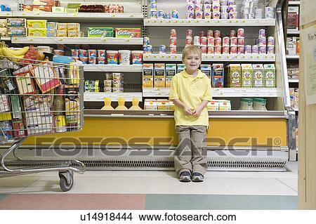 Young boy standing by fridge counter of supermarket View Large Photo Image Picture - Young boy standing by fridge counter of supermarket. Fotosearch