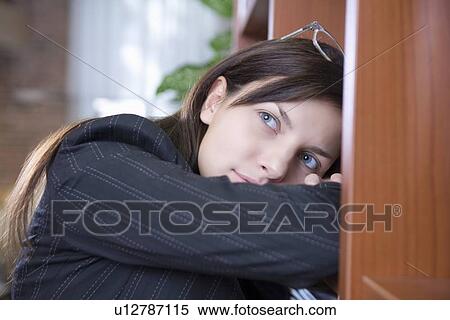 Stock Photography - Young designer leans on her arms looking for inspiration. Fotosearch
