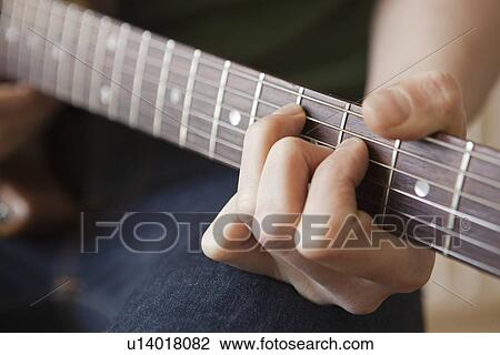 Young man playes chord on guitar View Large Photo Image Stock Image - Young man playes chord on guitar. Fotosearch