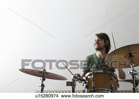 Young man plays drums with enjoyment View Large Photo Image Picture - Young man plays drums with enjoyment. Fotosearch
