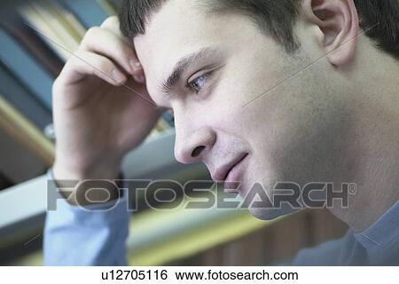 Young man reading in library leaning on elbow View Large Photo Image Stock Photograph - Young man reading in library leaning on elbow. Fotosearch