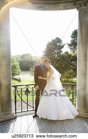Stock Image - Young newlywed couple embracing. Fotosearch
