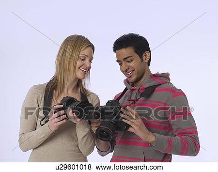 Stock Photo - Young photographers with cameras studio shot. Fotosearch