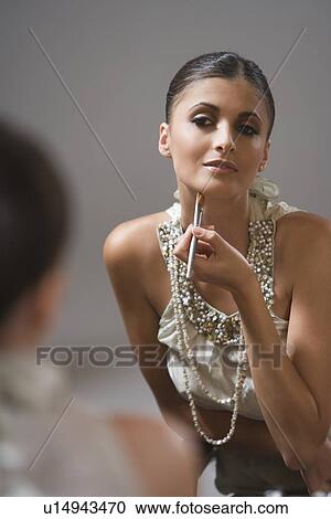 Stock Image - Young woman applies foundation. Fotosearch
