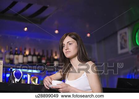 Young woman drinking tea at bar View Large Photo Image Stock Photo - Young woman drinking tea at bar. Fotosearch