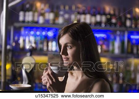 Stock Photography - Young woman drinking tea at bar. Fotosearch