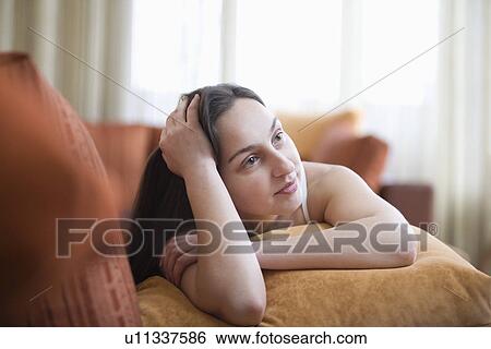 Young woman lying on sofa portrait View Large Photo Image Stock Photograph - Young woman lying on sofa portrait. Fotosearch