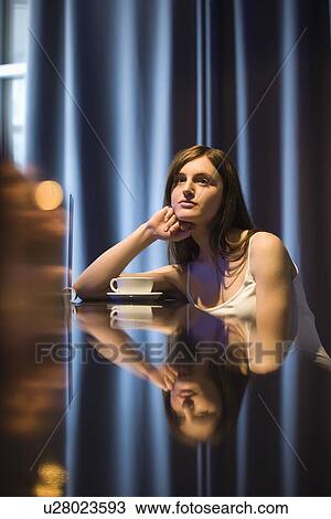Stock Image - Young woman relaxing at bar. Fotosearch
