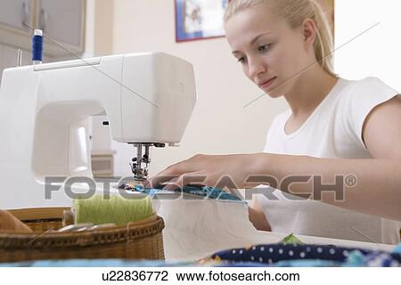 Young woman sits making patchwork at sewing machine View Large Photo Image Stock Image - Young woman sits making patchwork at sewing machine. Fotosearch