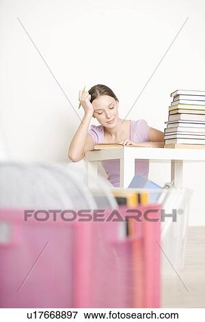 Young woman sits working at books View Large Photo Image Stock Photo - Young woman sits working at books. Fotosearch