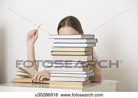 Young woman sits working at books View Large Photo Image Stock Photo - Young woman sits working at books. Fotosearch