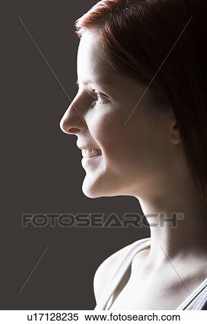 Stock Photography - Young woman smiling side view portrait. Fotosearch