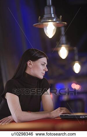 Young woman using laptop in cafe View Large Photo Image Stock Photograph - Young woman using laptop in cafe. Fotosearch