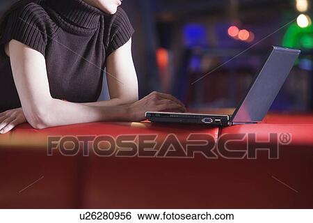 Young woman using laptop in cafe View Large Photo Image Stock Photograph - Young woman using laptop in cafe. Fotosearch
