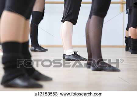 Stock Image - Young women practise ballet in a rehearsal room. Fotosearch