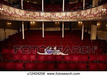 Young women sitting in theatre stalls View Large Photo Image Stock Photo - Young women sitting in theatre stalls. Fotosearch