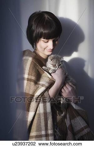 Woman in blanket stands holding kitten View Large Photo Image Stock Image - Woman in blanket stands holding kitten. Fotosearch