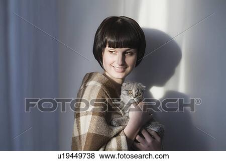 Woman in blanket stands holding kitten View Large Photo Image Stock Photo - Woman in blanket stands holding kitten. Fotosearch
