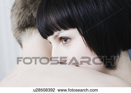 Woman looks over shouler of man she's embracing View Large Photo Image Stock Image - Woman looks over shouler of man she's embracing. Fotosearch