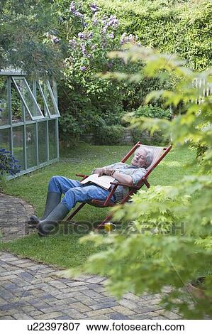 Gardener sleeps on deckchair in back garden View Large Photo Image Stock Photo - Gardener sleeps on deckchair in back garden. Fotosearch