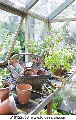 Stock Image - Gardening equipment on workbench in potting shed. Fotosearch
