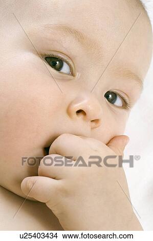 Infant child chewing on hand View Large Photo Image Picture - Infant child chewing on hand. Fotosearch