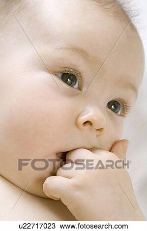 Infant child chewing on hand View Large Photo Image Stock Image - Infant child chewing on hand. Fotosearch