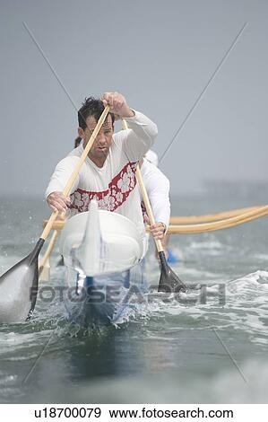 Stock Photo - Outrigger canoeing team on water. Fotosearch