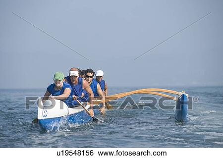 Stock Photograph - Outrigger canoeing team on water. Fotosearch