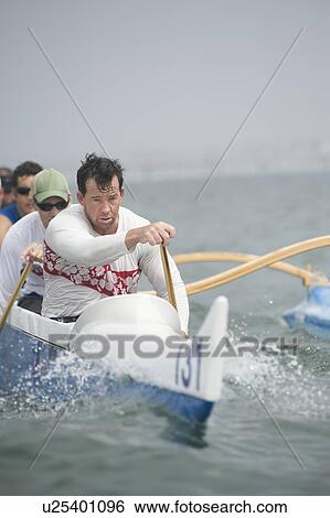 Stock Photograph - Outrigger canoeing team on water. Fotosearch
